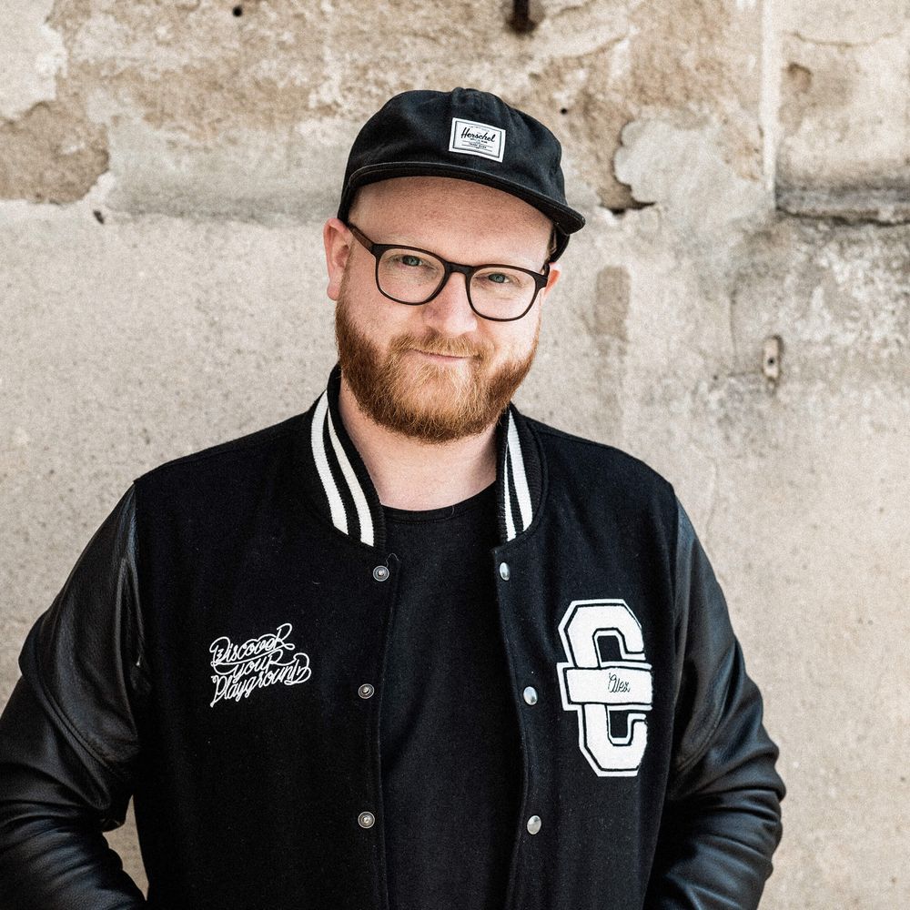 Auf dem Bild ist Jonny zu sehen. Er trägt eine schwarze Cromatics-Jacke und schaut keck.