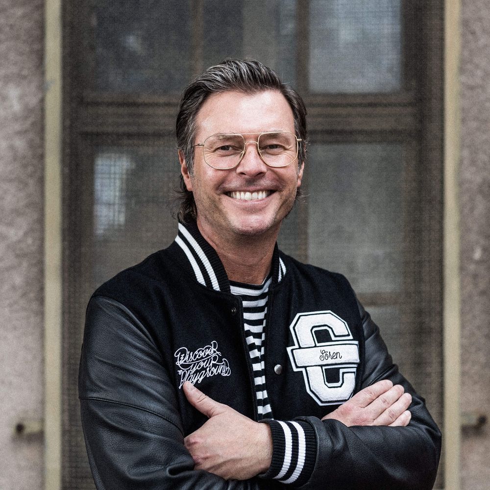 Auf dem Bild ist Sören zu sehen. Er trägt eine schwarze Cromatics-Jacke und lächelt.