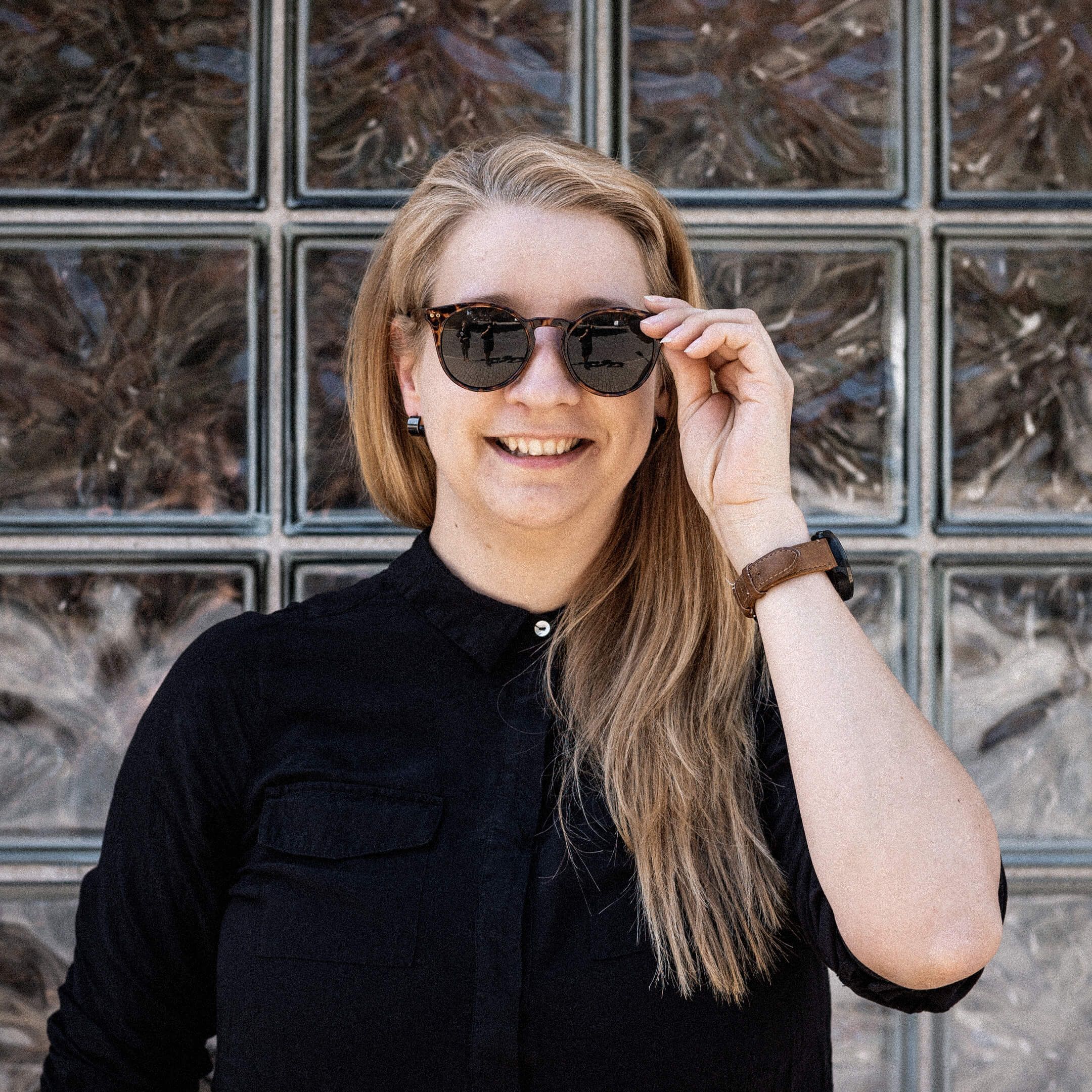 Hier ist Katha zu sehen. Sie trägt ein schwarzes Shirt und eine Sonnenbrille.