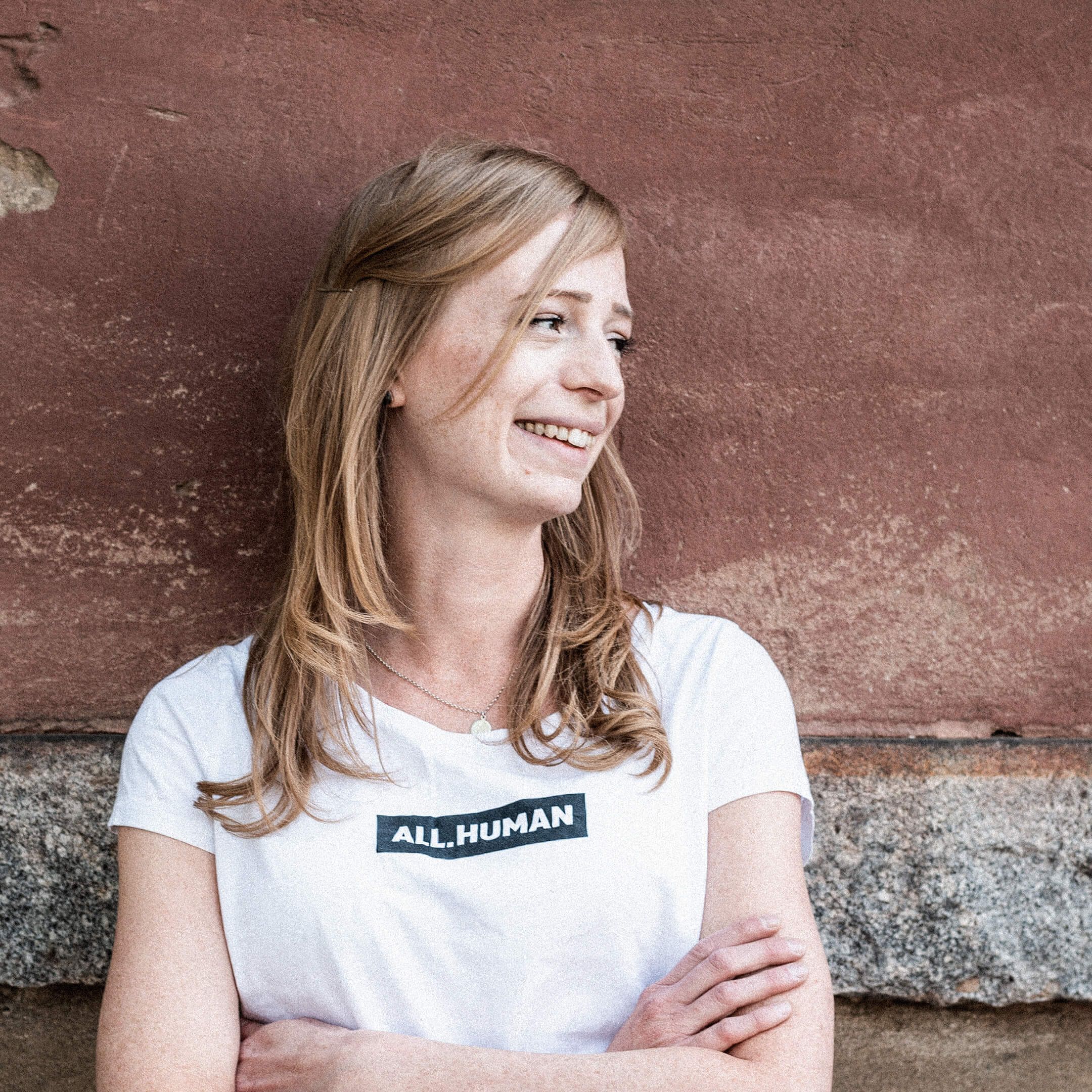 Hier ist Marnie zu sehen. Sie trägt ein weißes Shirt und schaut verträumt nach rechts.