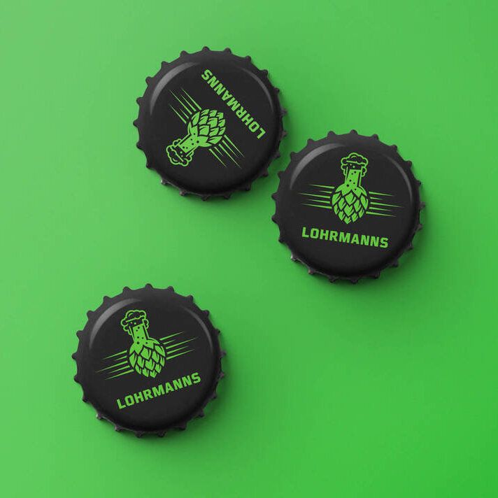 Drei schwarze Kronkorken mit grünem Lohrmanns-Logo